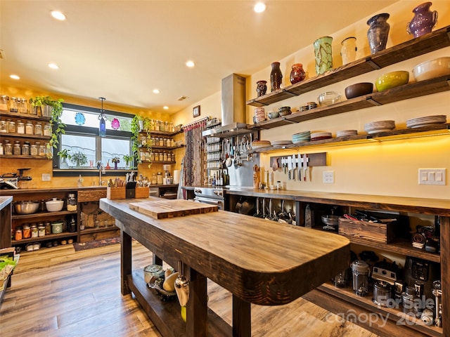 dining area with wet bar, recessed lighting, and wood finished floors