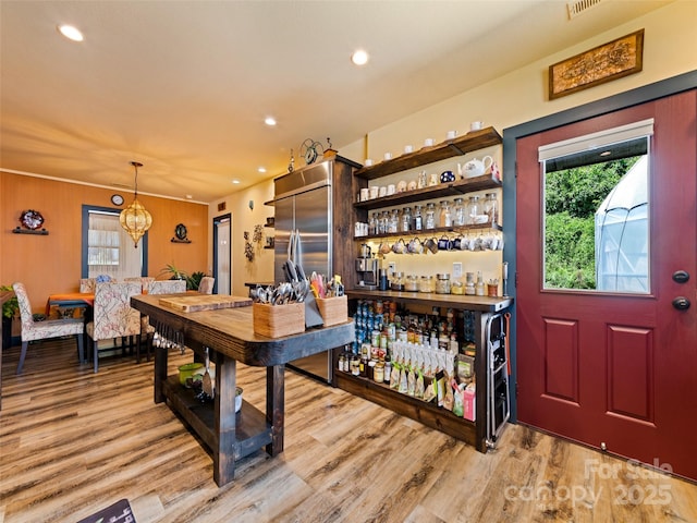 interior space with a chandelier, recessed lighting, light wood-style flooring, and a dry bar