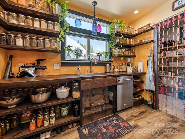 bar with wood finished floors, recessed lighting, wet bar, and a sink