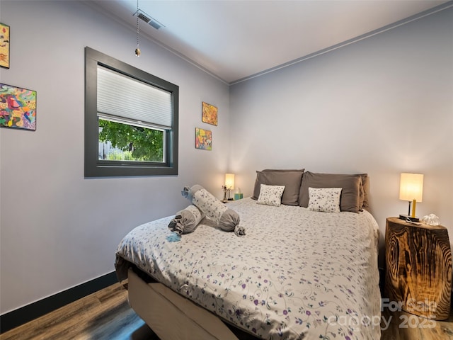 bedroom with dark wood-type flooring, baseboards, and visible vents