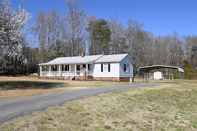 view of front of home with a porch, a front lawn, a carport, crawl space, and aphalt driveway