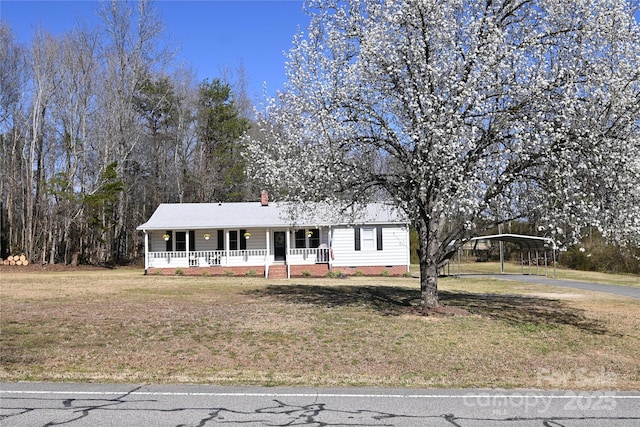 single story home with crawl space, a porch, a detached carport, and a front lawn