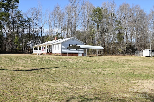 view of front of house with a storage unit, a detached carport, an outdoor structure, and a front lawn