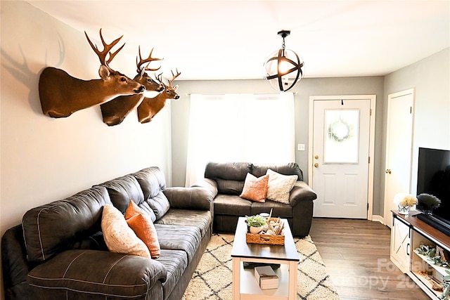 living area featuring a notable chandelier and wood finished floors