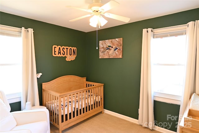 bedroom with multiple windows, baseboards, carpet, and a nursery area