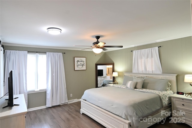 bedroom featuring a ceiling fan, crown molding, wood finished floors, and baseboards