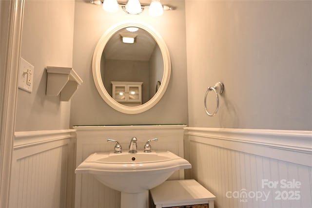 bathroom featuring a sink and a wainscoted wall