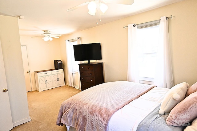 bedroom featuring light colored carpet and a ceiling fan