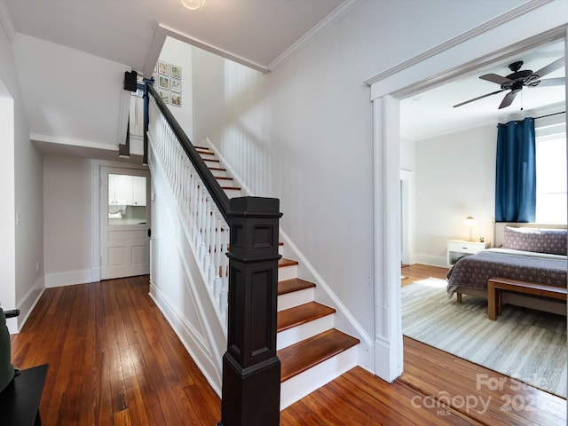 stairs featuring baseboards, ornamental molding, a ceiling fan, and hardwood / wood-style flooring