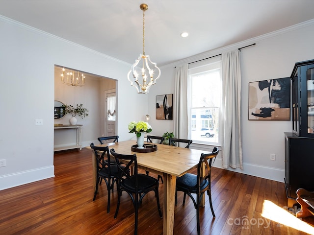 dining room featuring dark wood finished floors, a notable chandelier, crown molding, and baseboards