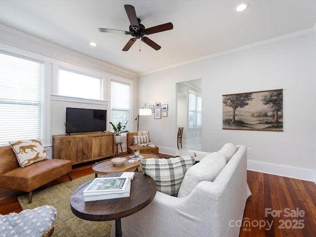 living area with plenty of natural light, crown molding, baseboards, and wood finished floors