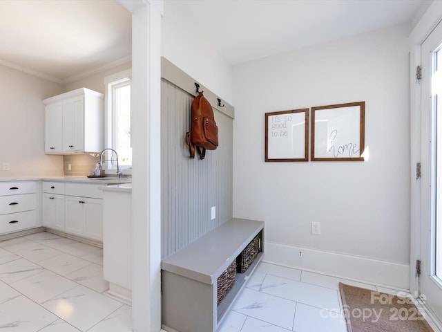 mudroom with a sink, baseboards, marble finish floor, and crown molding