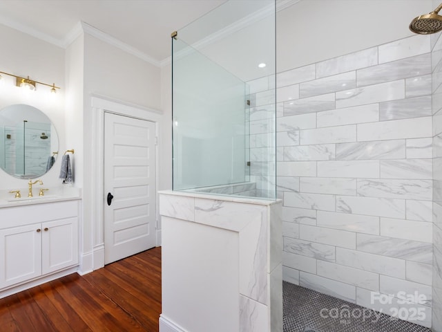 full bath with vanity, wood finished floors, a walk in shower, and ornamental molding