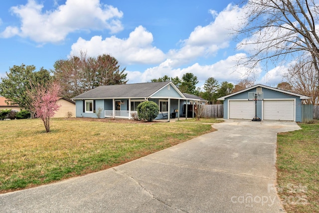 ranch-style house featuring a detached garage, an outbuilding, a porch, and a front lawn