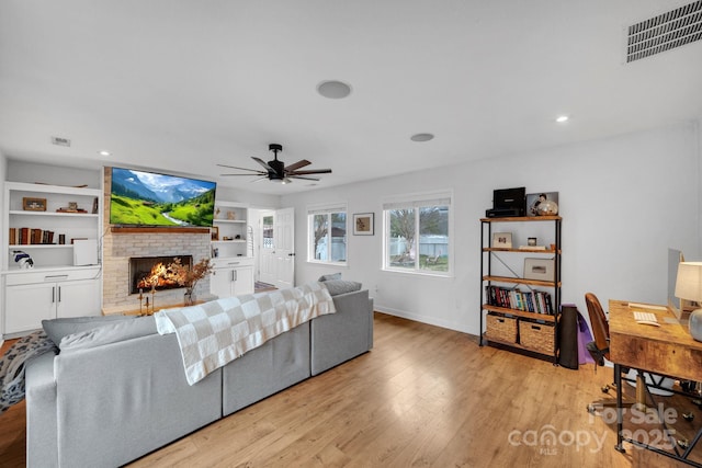 living room with visible vents, ceiling fan, recessed lighting, light wood-style flooring, and a fireplace