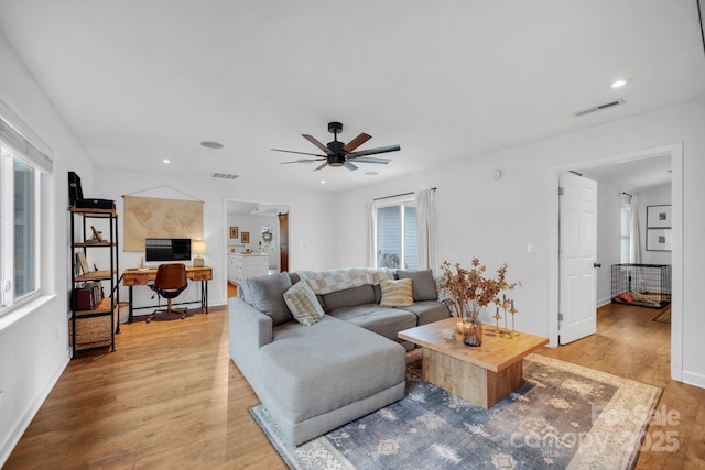 living area with light wood-type flooring, visible vents, ceiling fan, and recessed lighting