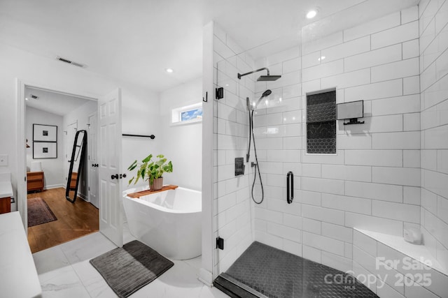 bathroom featuring visible vents, marble finish floor, recessed lighting, a shower stall, and a freestanding bath