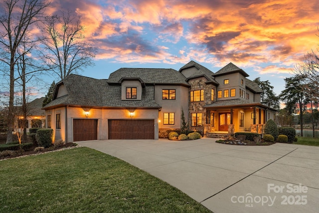 french provincial home featuring stucco siding, driveway, a front lawn, stone siding, and an attached garage