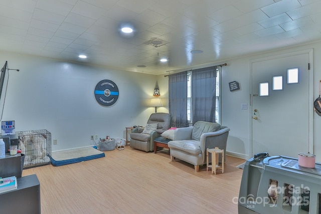 sitting room with baseboards and wood finished floors