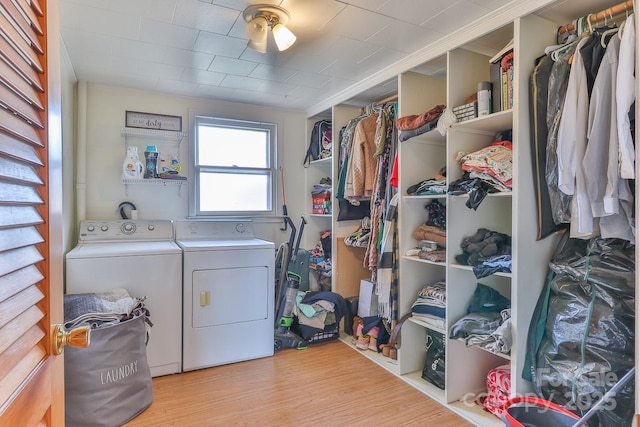 washroom featuring laundry area, wood finished floors, and washing machine and dryer