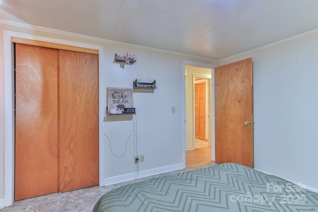 bedroom with crown molding, baseboards, and a closet