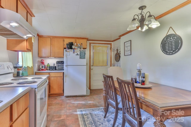 kitchen with crown molding, under cabinet range hood, a chandelier, light countertops, and white appliances