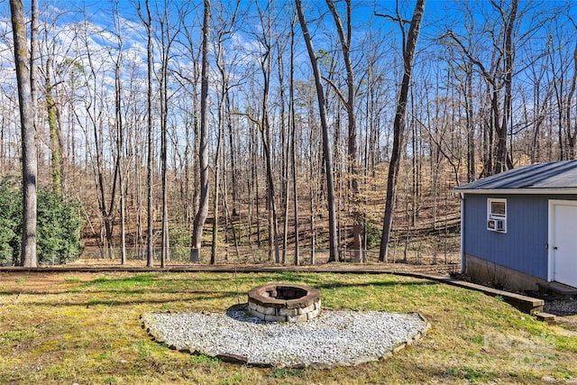 view of yard featuring an outbuilding, fence, and an outdoor fire pit