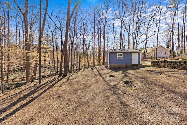 view of yard with an outdoor structure, fence, and a shed