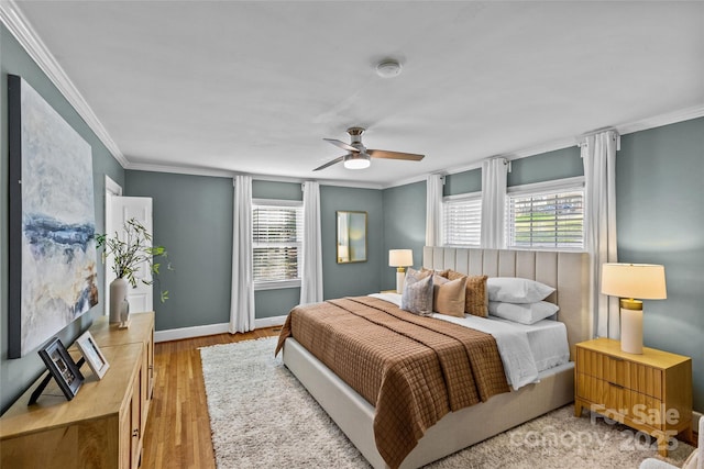 bedroom featuring ceiling fan, baseboards, wood finished floors, and ornamental molding