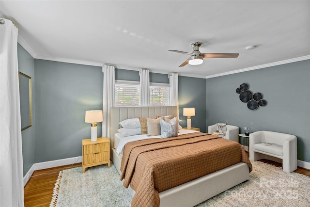 bedroom with crown molding, baseboards, and wood finished floors