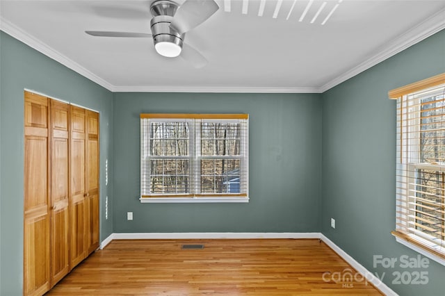 unfurnished bedroom featuring ornamental molding, light wood-style floors, visible vents, and baseboards