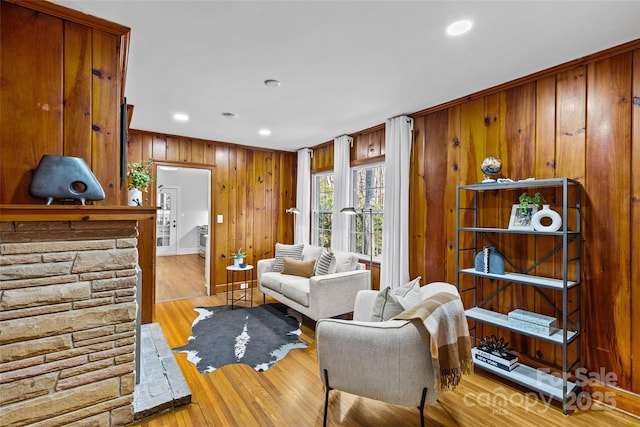 sitting room with recessed lighting, wood finished floors, and wood walls