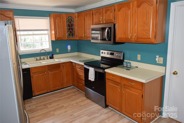 kitchen featuring brown cabinetry, ornamental molding, stainless steel appliances, and a sink