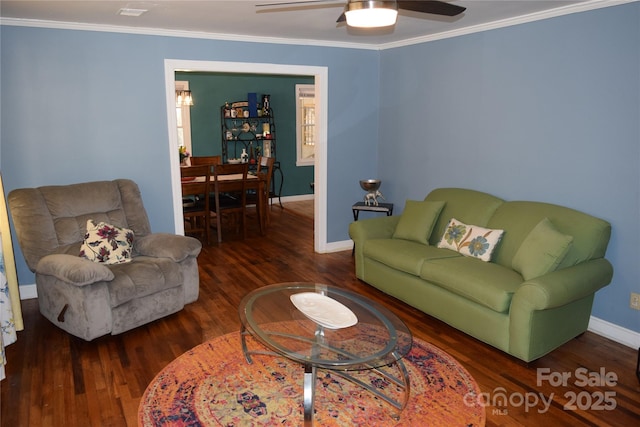 living area with baseboards, wood finished floors, ornamental molding, and a ceiling fan