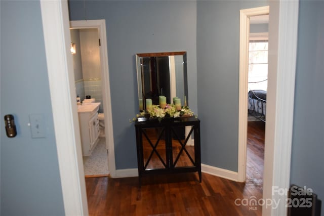 hallway with wood finished floors and baseboards