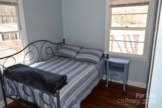 bedroom featuring multiple windows, wood finished floors, and baseboards