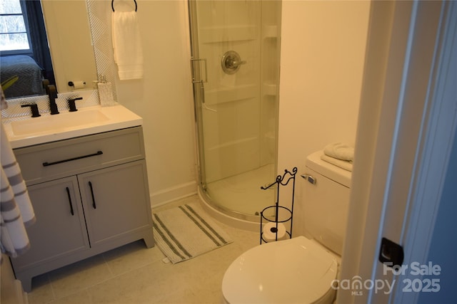 ensuite bathroom featuring tile patterned floors, toilet, a stall shower, and vanity