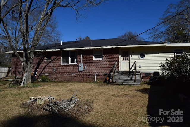 back of property with a yard, brick siding, and crawl space