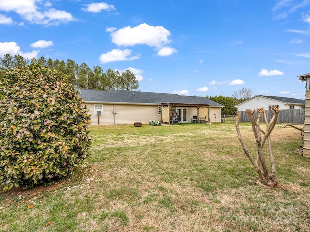 back of house with a lawn and fence