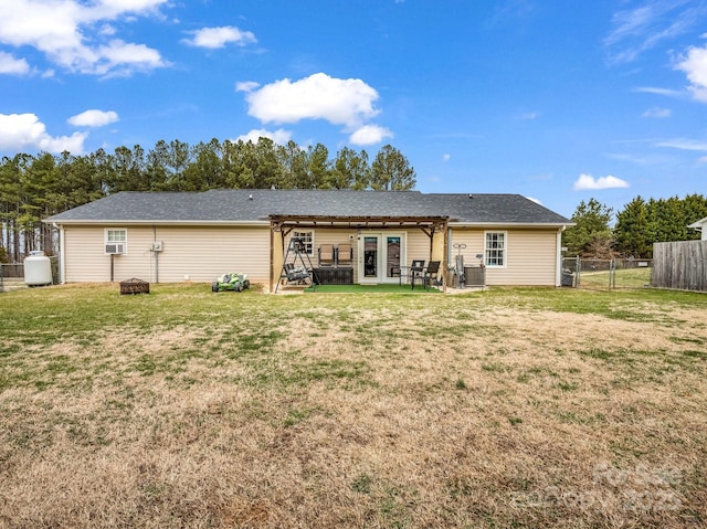 rear view of house with a yard, fence private yard, a pergola, and an outdoor fire pit