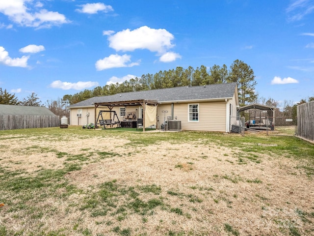 rear view of house with a yard, cooling unit, and a fenced backyard