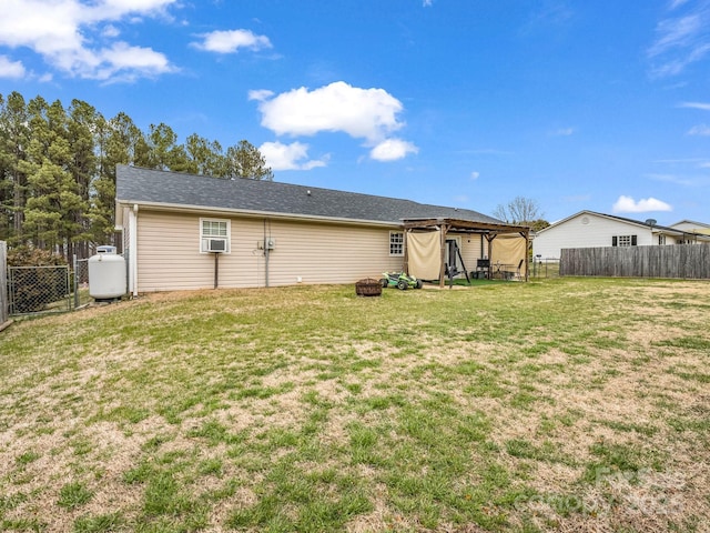 back of house with a yard, a fenced backyard, and an outdoor fire pit