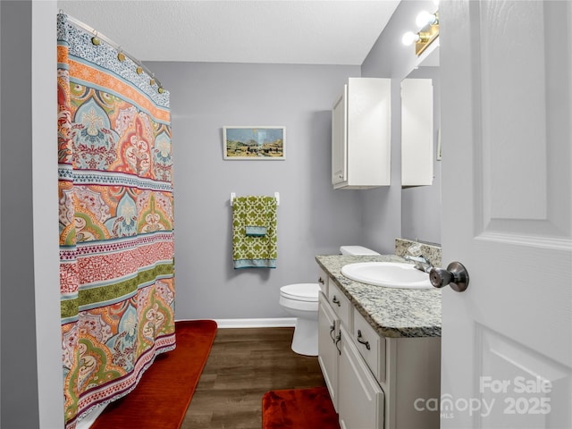 full bathroom with baseboards, toilet, vanity, wood finished floors, and a textured ceiling