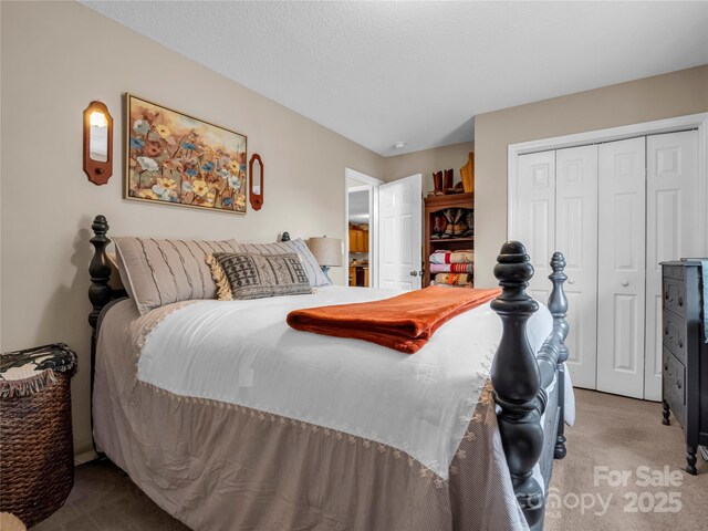 bedroom featuring a closet, light colored carpet, and a textured ceiling