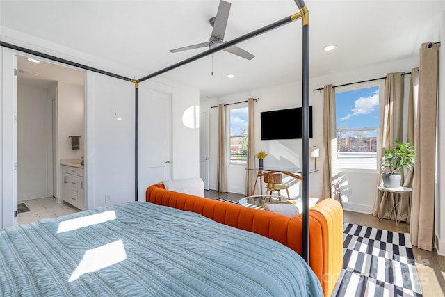 bedroom featuring ensuite bathroom, baseboards, recessed lighting, and light wood-style floors