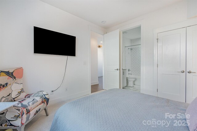 bedroom with connected bathroom and baseboards
