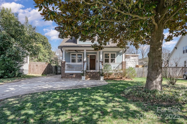 view of front of home featuring a porch, fence, a front yard, and crawl space