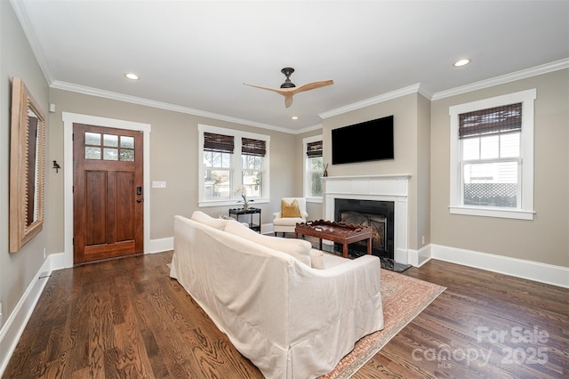 living area with a wealth of natural light, dark wood-style floors, and a fireplace with flush hearth