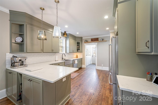 kitchen with open shelves, a peninsula, stainless steel appliances, crown molding, and independent washer and dryer