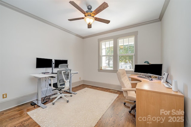 office space with baseboards, a ceiling fan, wood finished floors, and crown molding